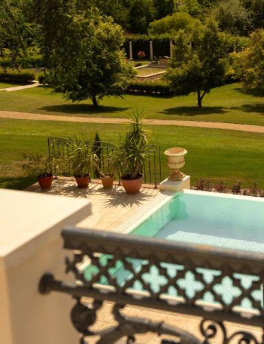 a bench sitting next to a swimming pool with plants at Kastély szállás in Nagyréde