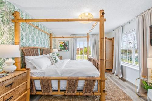 a bedroom with a wooden canopy bed and a window at HeatedPool HotTub 3min2Beach GameRm PetFriendly in Saint Augustine