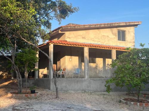 une maison avec 2 chaises sur la terrasse couverte dans l'établissement Casa Linda Barrerinhas - Ma, à Barreirinhas