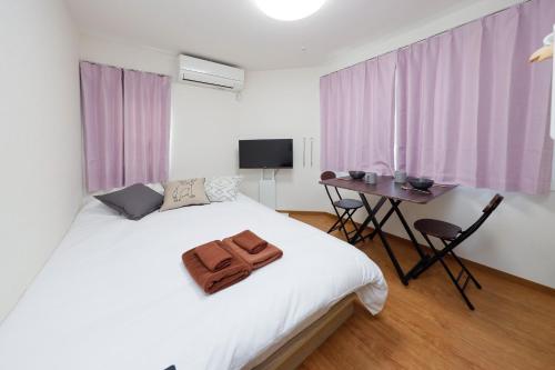 a bedroom with a white bed with a wooden floor at Zenith Garden TOGOSHI - Vacation STAY 74119v in Tokyo