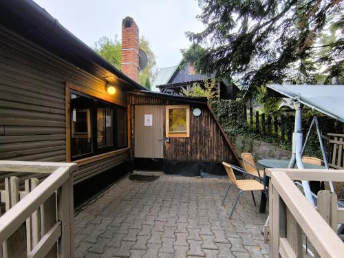 a patio with a table and chairs next to a building at Chata pri 7 jazerách s vyvýšenou terasou in Štiavnické Bane