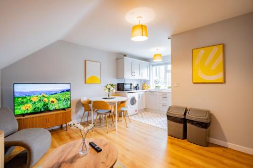 a living room with a television and a table with chairs at Location! Location! City Centre Townhouse Sleeps 6 in Galway