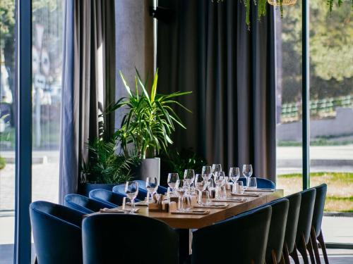 a long table with wine glasses and blue chairs at Novotel Bishkek City Center in Bishkek