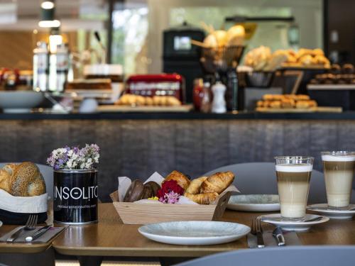 Ibis Styles Madrid City Las Ventas في مدريد: طاولة عليها أكواب من القهوة والمعجنات