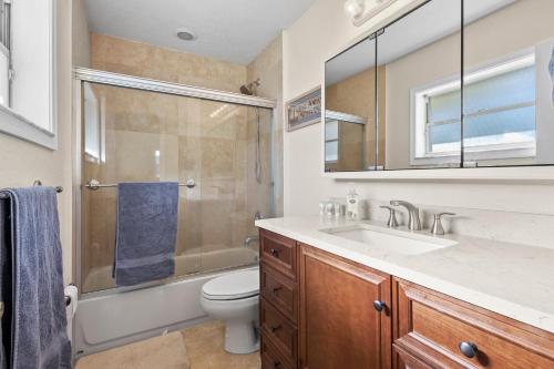 a bathroom with a sink and a toilet and a shower at Ocean Song House in Fort Pierce