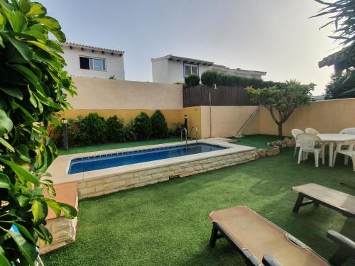 a backyard with a swimming pool and a house at Bungalow con piscina 28 in Gran Alacant