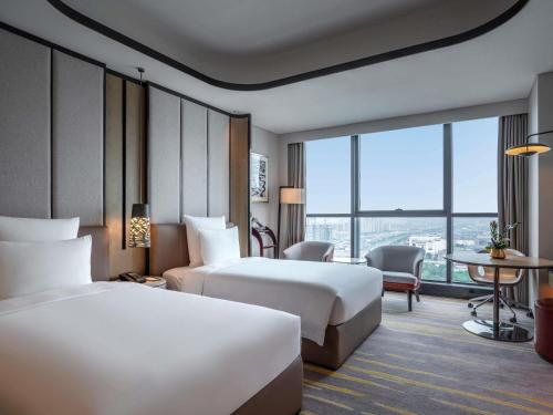 Ένα ή περισσότερα κρεβάτια σε δωμάτιο στο Pullman Suzhou Zhonghui