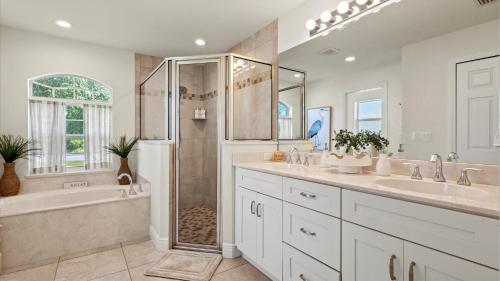 a bathroom with two sinks and a shower and a tub at Gem of Jensen Beach in Jensen Beach