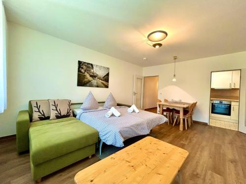 a living room with a green couch and a table at Waldgeflüster, Montana Haus in Oberstdorf
