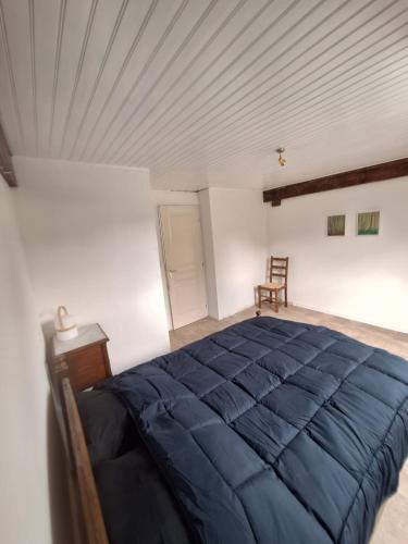 una camera da letto con un grande letto blu in una stanza di Maison Équilibre a Royère-de-Vassivière