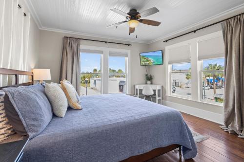 1 dormitorio con 1 cama, ventilador de techo y ventanas en The Porch at Fort Pierce, en Fort Pierce