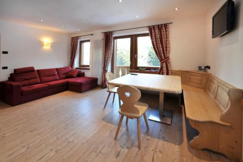 a living room with a table and a couch at Appartamenti da Nica e Diego in Borca di Cadore