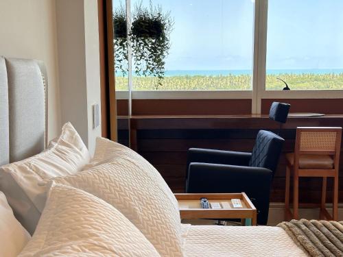 a bedroom with a bed and a chair and a window at Boho Luxo Sunset | Hidro, Alexa Top de linha & + in Recife