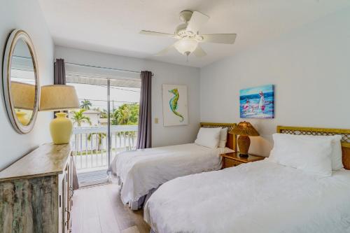 two beds in a room with a window at Siesta Key Exclusive Beachside Compound 3 Units in Point O'Rocks