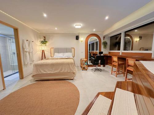 a bedroom with a bed and a table and a desk at Boho Luxo Sunset | Hidro, Alexa Top de linha & + in Recife