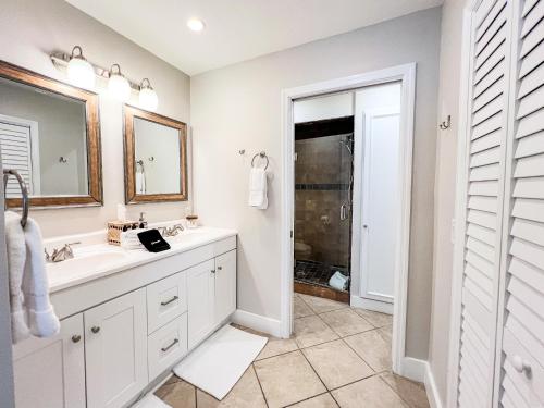 a white bathroom with a sink and a mirror at 100' from the beach, Charming 1BR Beachside Retreat in Point O'Rocks