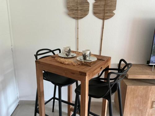une table en bois avec des chaises et deux tasses dessus dans l'établissement Kalista - Studio Luxueux - Anse Marcel, à Saint-Martin