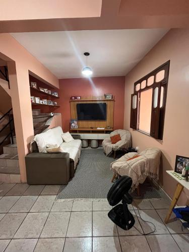 a living room with a couch and a tv at Quartos privativos e casa compartilhada no centro de Belém in Belém
