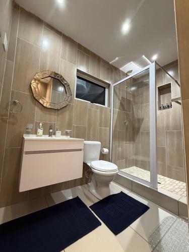 a bathroom with a toilet and a sink and a shower at Umoya Executive Apartment in Mbabane