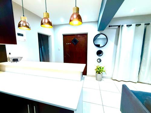 a kitchen with two pendant lights above a counter at Umoya Executive Apartment in Mbabane