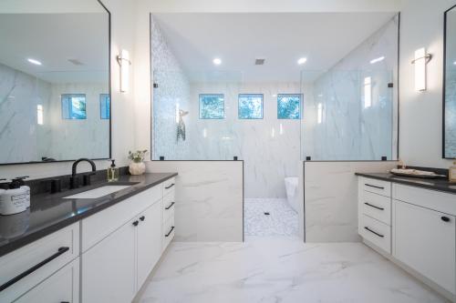 a white bathroom with a shower and a sink at New Contruction Modern Outdoor Oasis Prime Location in Southgate