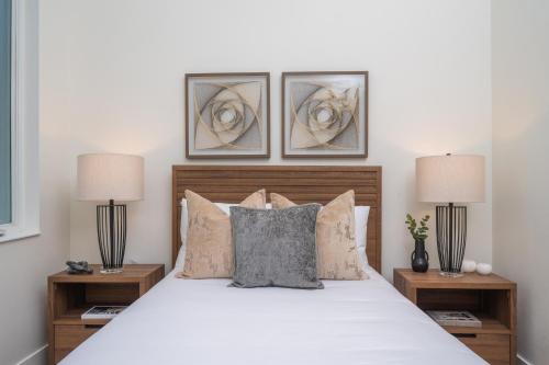 a bedroom with a white bed with two lamps at New Contruction Modern Outdoor Oasis Prime Location in Southgate