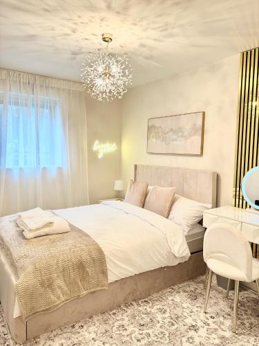 a bedroom with a large bed and a chandelier at Lux Stays - 2BR Leeds City Centre Apartment - Ground Floor with Free Parking in Leeds