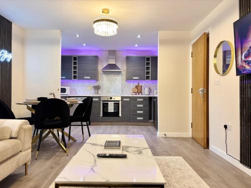 a kitchen and living room with a table and a couch at Lux Stays - 2BR Leeds City Centre Apartment - Ground Floor with Free Parking in Leeds