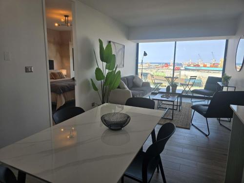 ein Wohnzimmer mit einem weißen Tisch und Stühlen in der Unterkunft HOM I Ideal Depto 2D2B Frente al Mall Antofagasta in Antofagasta