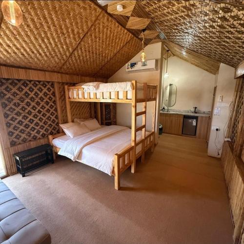 a bedroom with a bunk bed in a room at Jabal Hatt Resthouse in Khawr Zammah