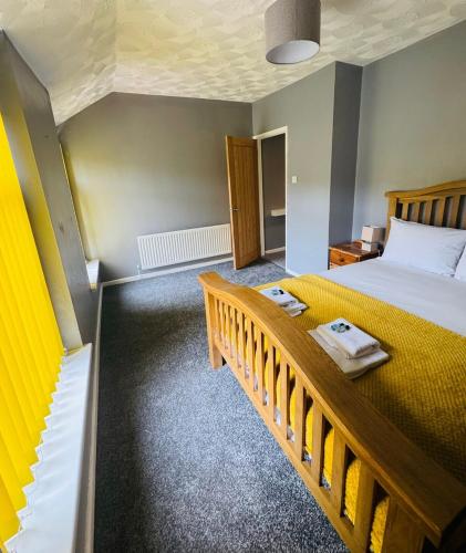 a bedroom with a large bed and a staircase at Gaen - Ty Seren in Abertillery