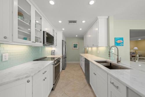cocina grande con armarios blancos y electrodomésticos de acero inoxidable en Charming Chert, en Isla de Sanibel
