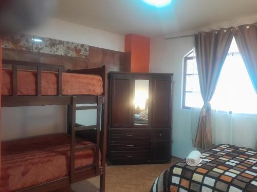 バーニョスにあるSANPE Apartmentのベッドルーム1室(二段ベッド、ドレッサー、窓付)が備わります。