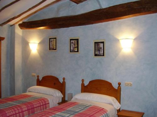 a bedroom with two beds and two lights on the wall at Casa Rural Restaurante Casino Munilla in Munilla