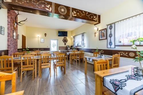 a restaurant with wooden tables and wooden chairs at Willa Pod Wierchem in Bukowina Tatrzańska