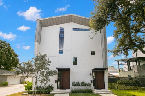 a white house with brown doors at New The Artist House - Luxury Hyde Park Home in Tampa