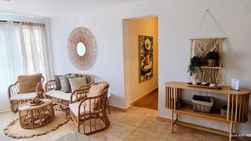 カラン・ポルテルにあるEl Escape - confort y calmaのリビングルーム(籐の椅子、テーブル付)