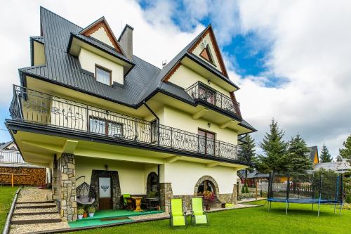 a house with a playground in front of it at Willa Pod Wierchem in Bukowina Tatrzańska
