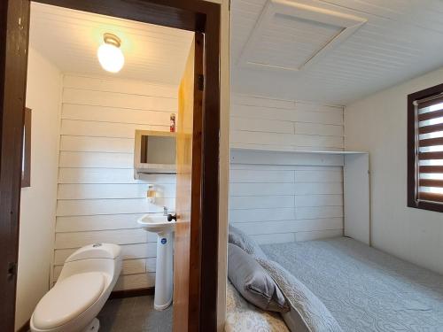 a small bathroom with a bed and a sink at Quillon Cabaña Privada Vista al Valle in Quillón