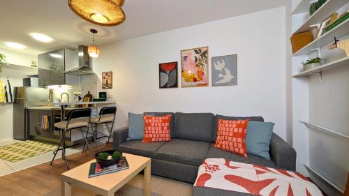 ein Wohnzimmer mit Couch und Küche in der Unterkunft Bella Luna Luxury Suites - Warm & Modern Apt Near Old Town & Museums in Warschau