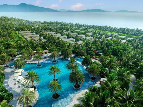 - une vue aérienne sur le complexe avec une piscine et des palmiers dans l'établissement Mövenpick Resort Cam Ranh, à Cam Ranh
