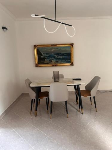 a dining room table with chairs and a painting on the wall at Departamento a una cuadra del angel de la independencia in Mexico City