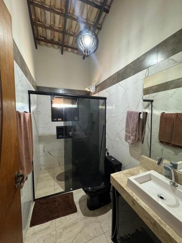 a bathroom with a shower and a toilet and a sink at Chácara Conquistando II in Jarinu