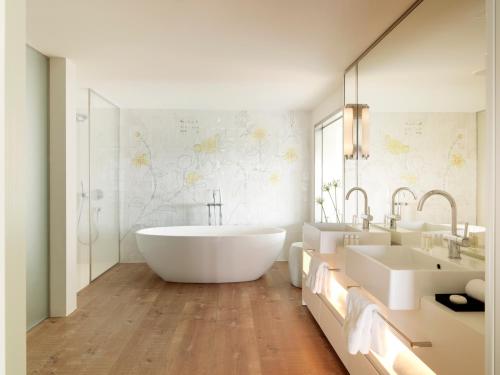 a bathroom with a tub, sink, and toilet at Hotel Camiral at PGA Catalunya in Caldes de Malavella
