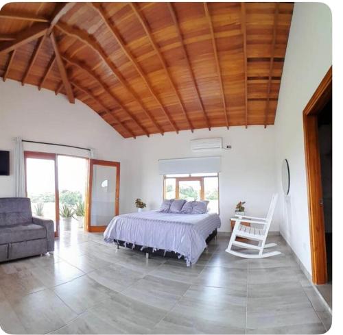 a bedroom with a bed and a table and a couch at El Encanto de las Aguas in Necoclí