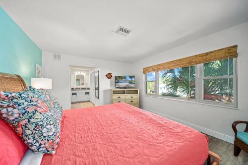 a bedroom with a red bed and a window at Sandcastle Suite - 632C in Siesta Key