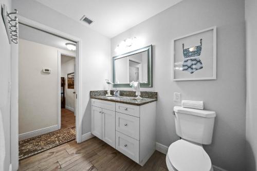 a bathroom with a toilet and a sink and a mirror at Sandcastle Suite - 632C in Siesta Key