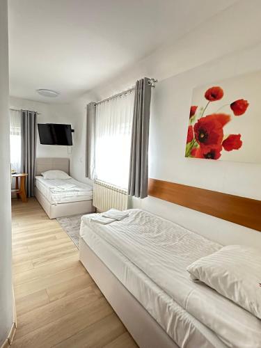 a hotel room with two beds and a television at Motel Za Miedzą in Bralin