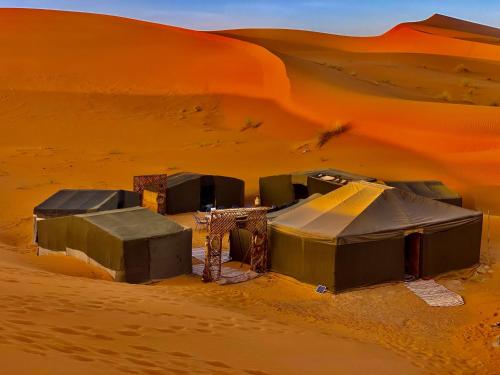 a camp in the desert with a sand dune at Merzouga Standard Camp in Merzouga