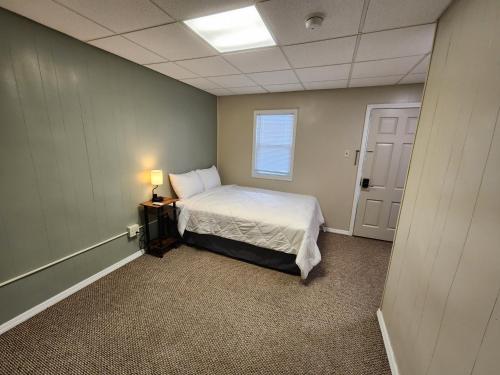 Una pequeña habitación con una cama y una ventana. en Dunnstown Lodge, en Lock Haven